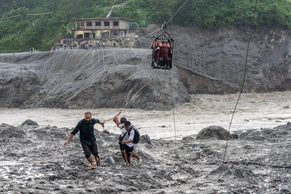 Trading food for medicine and crossing the river by zip line are part of life in Nepal flood zone