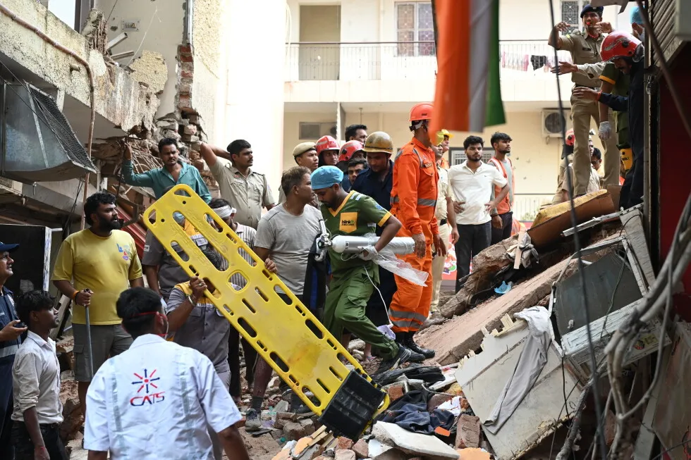 Building collapse in New Delhi kills 1 and traps dozens of others