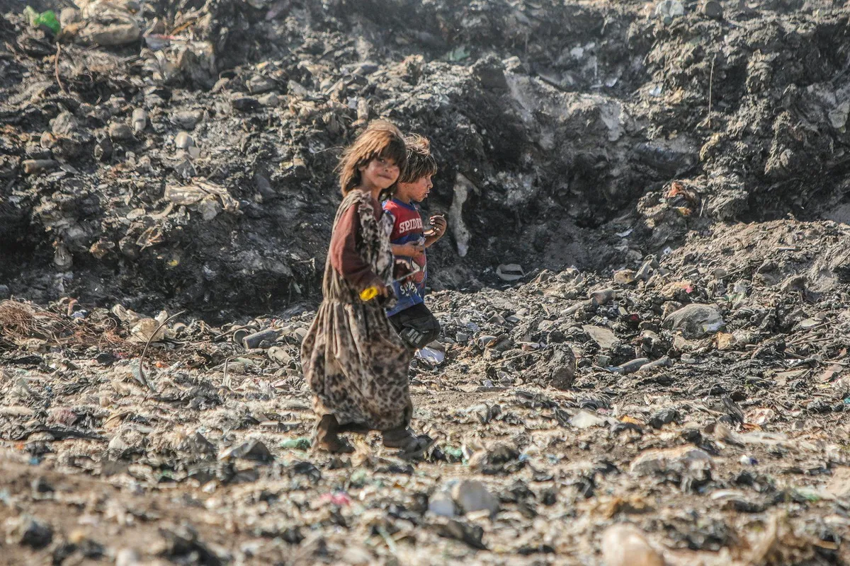 Displaced Syrians dig through hills of garbage to make a living