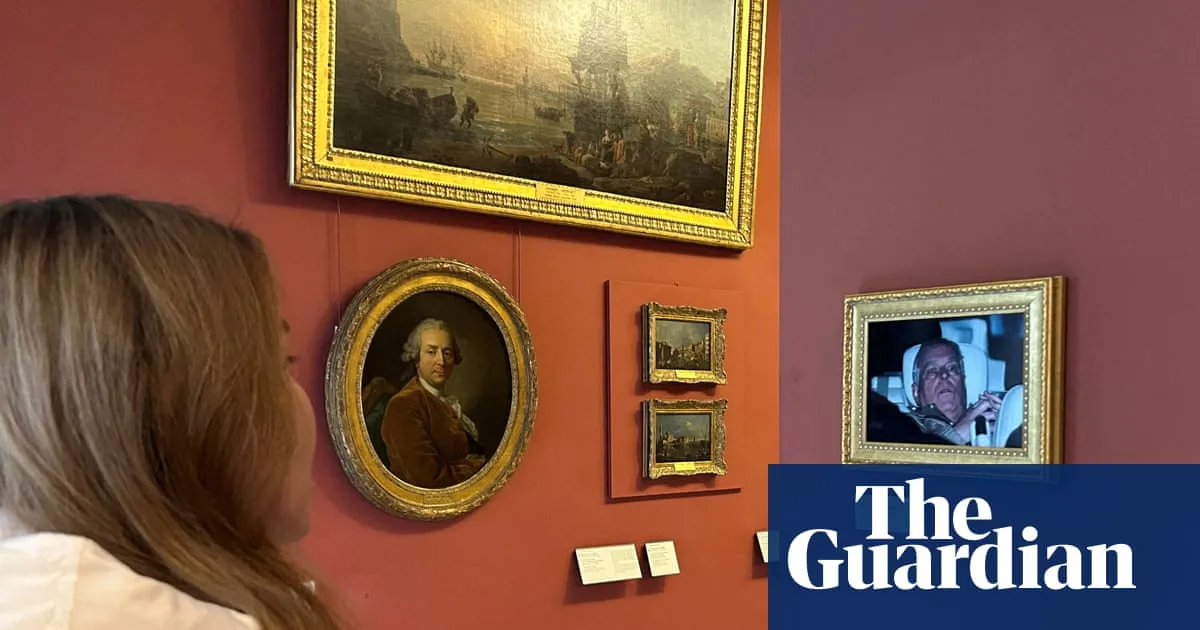 Activists hang photo of Andrew leaving police custody in the Louvre