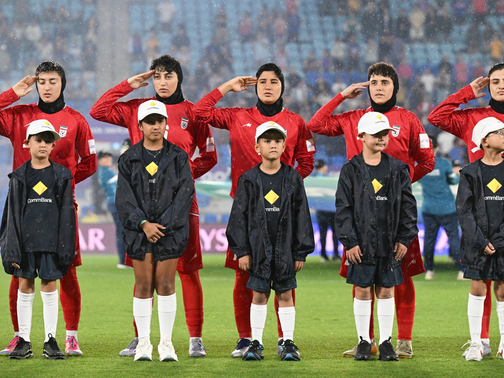 Iran women’s football team sing anthem amid safety concerns during war