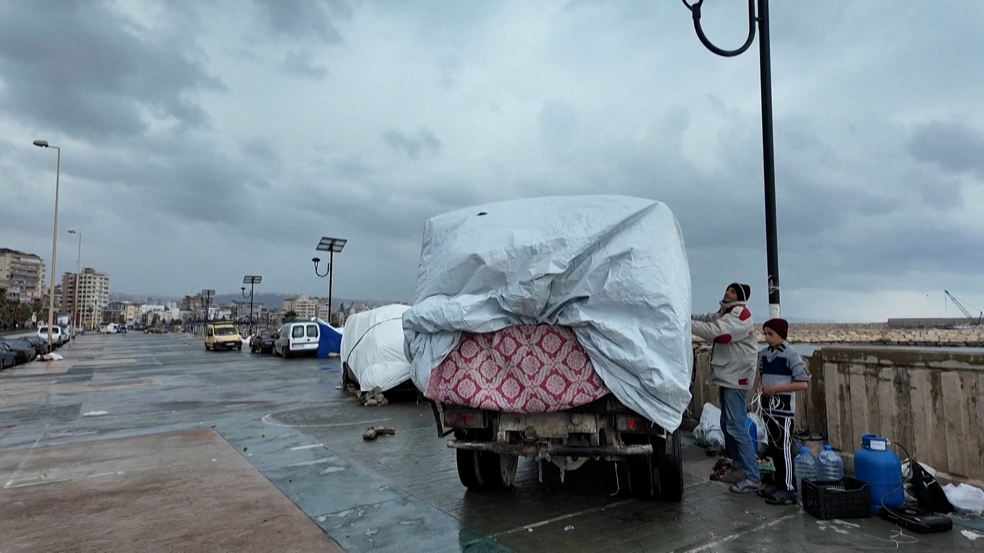 Displaced families in Lebanon turn vehicles into rain-soaked shelters