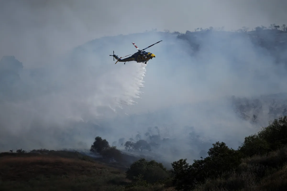 Helicopters douse flames threatening hillside homes in California