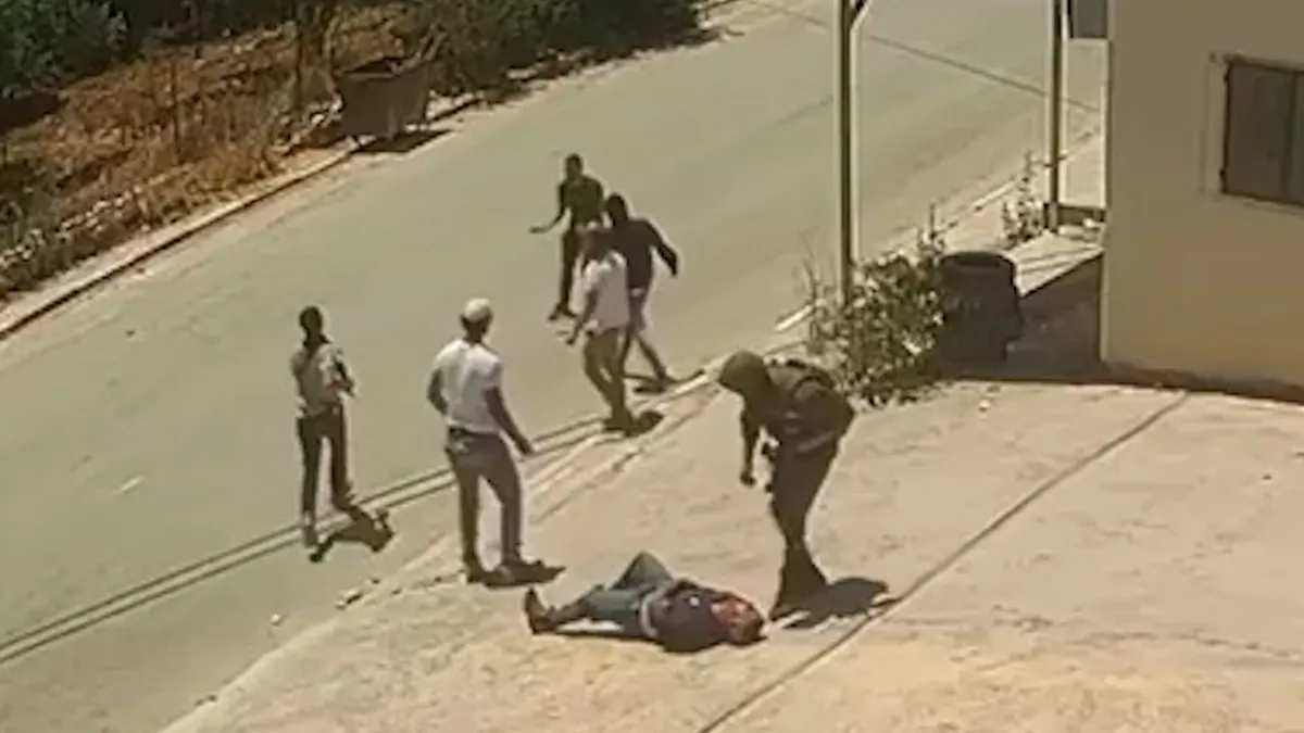 Video shows Israeli soldier and settlers assaulting two Palestinians